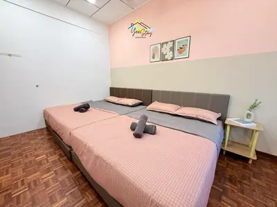 a bedroom with a bed with pink sheets and pink pillows at CozyKota8Pax 4MinsToJonker in Gua Sai