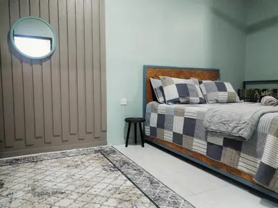a bedroom with a bed and a mirror on the wall at D'mesyar Homestay 3BR Fully airconds in Teluk Intan