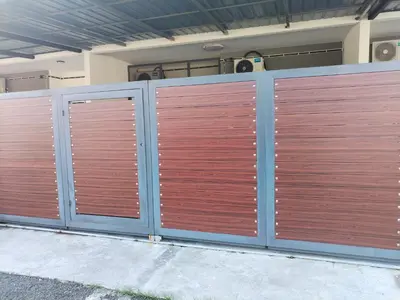 a pair of wooden gates in front of a building at D'mesyar Homestay 3BR Fully airconds in Teluk Intan