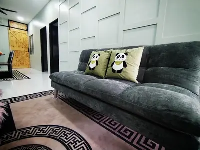 a couch with two pillows on it in a living room at D'mesyar Homestay 3BR Fully airconds in Teluk Intan