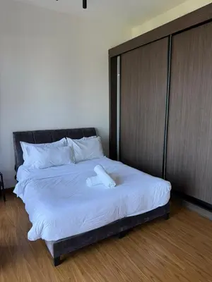 a large bed with a wooden headboard and white sheets at Beacon Executive Suites with Infinity Pool by BNB4U in George Town