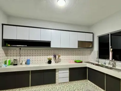a kitchen with white cabinets and a counter top at Grace Homestay Taiping in Taiping