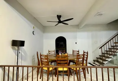 a dining room with a table and a ceiling fan at Grace Homestay Taiping in Taiping