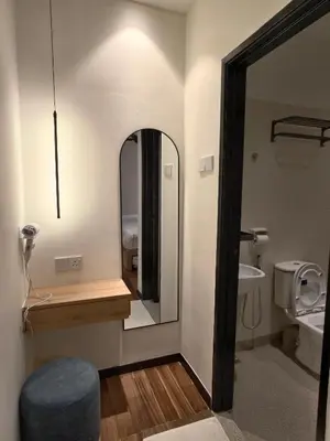 a bathroom with a mirror and a sink and a toilet at Domuss Guesthouse- 4B3B Tunas in Bayan Lepas