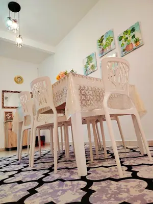 a white dining room table with four white chairs at Kuda Kepang Guesthouse in Sungai Petani