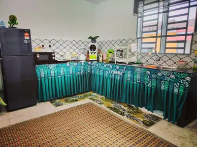 a kitchen with a fence and a counter with a table at Kuda Kepang Guesthouse in Sungai Petani