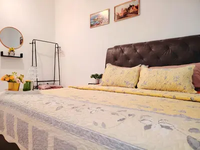 a bedroom with a large bed with a brown headboard at Kuda Kepang Guesthouse in Sungai Petani