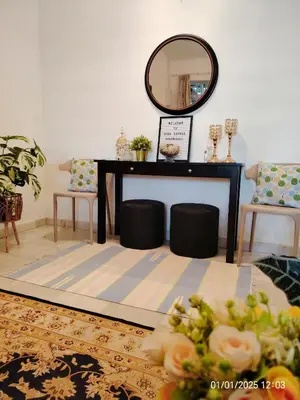 a living room with a table and a mirror at Kuda Kepang Guesthouse in Sungai Petani