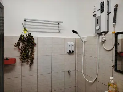 a bathroom with a shower with a phone on the wall at Kuda Kepang Guesthouse in Sungai Petani