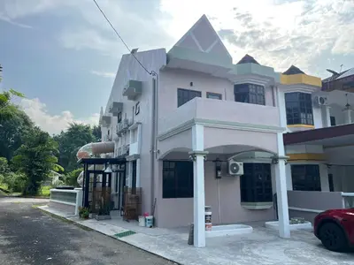 a white building with an archway on a street at Capy House Taiping in Taiping