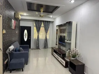 a living room with a blue couch and a television at D' Mutiara Homestay in Simpang Ampat