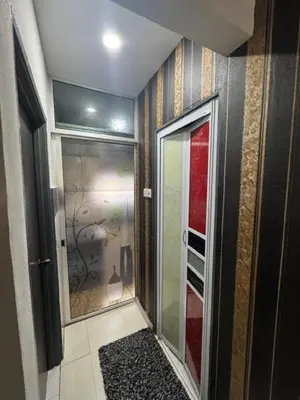 a walk in shower in a room with a glass door at D' Mutiara Homestay in Simpang Ampat