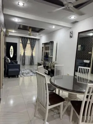 a living room with a dining room table and chairs at D' Mutiara Homestay in Simpang Ampat