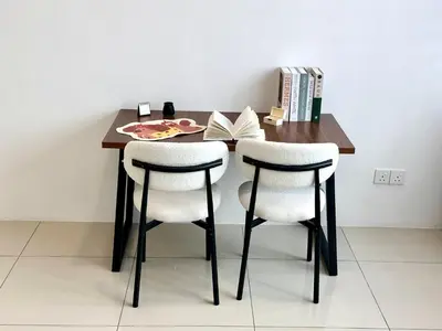 a dining room table with two chairs and a book at 4BR Cozy Villa for 16 Pax Quiet Area & Spacious in Simpang Ampat