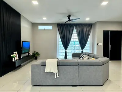 a living room with a gray couch and a tv at 4BR Cozy Villa for 16 Pax Quiet Area & Spacious in Simpang Ampat