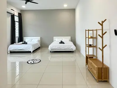 two beds in a room with white walls at 4BR Cozy Villa for 16 Pax Quiet Area & Spacious in Simpang Ampat