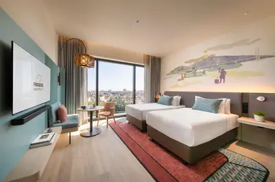 a hotel room with two beds and a flat screen tv at Capri by Fraser, Penang in George Town