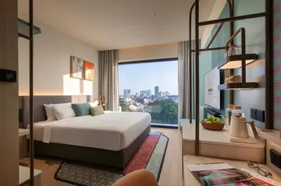 a hotel room with a bed and a large window at Capri by Fraser, Penang in George Town