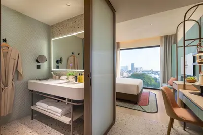 a bathroom with a sink and a bed and a mirror at Capri by Fraser, Penang in George Town