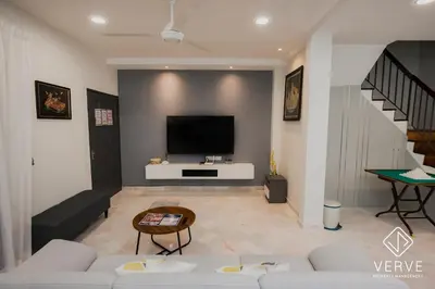 a living room with a couch and a tv on a wall at Ipoh Yistay by Verve 10 Pax 4B4B in Ipoh
