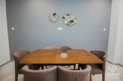 a dining room table with chairs and a clock on the wall at Ipoh Yistay by Verve 10 Pax 4B4B in Ipoh