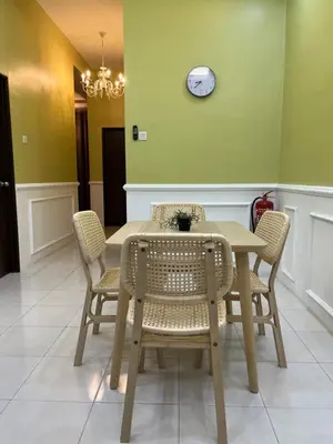 a dining room table and chairs with a clock on the wall at UHhomestay in Kampong Tok Bedu
