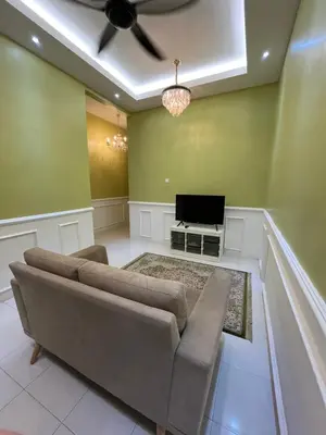 a living room with a couch and a flat screen tv at UHhomestay in Kampong Tok Bedu