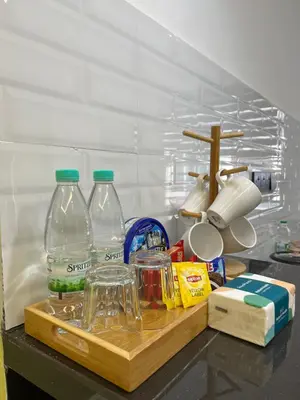 a kitchen counter with two plastic bottles on a cutting board at UHhomestay in Kampong Tok Bedu