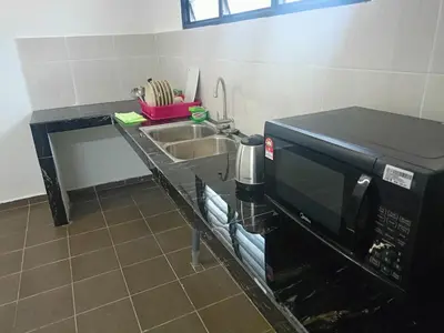 a kitchen counter with a microwave and a sink at Ipoh budget house in Ipoh