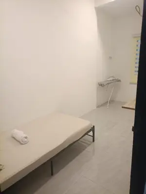 a white room with a bed and a table at Ipoh budget house in Ipoh