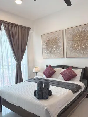 a bedroom with a bed with two pairs of shoes on it at Homii Ipoh CBD in Ipoh