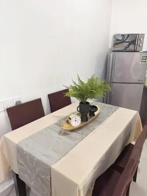a dining room table with a plant on top of it at Homii Ipoh CBD in Ipoh
