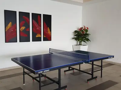 a blue ping pong table in a room with paintings at Homii Ipoh CBD in Ipoh