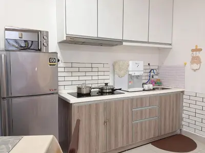 a kitchen with white cabinets and a stainless steel refrigerator at Homii Ipoh CBD in Ipoh