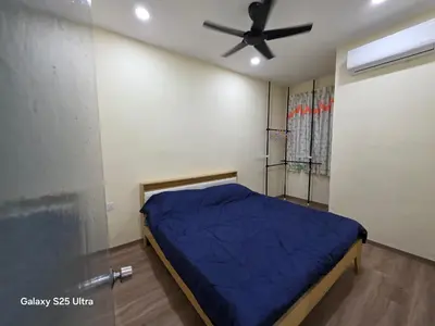 a bedroom with a blue bed and a ceiling fan at Bliss Homestay in Simpang Ampat