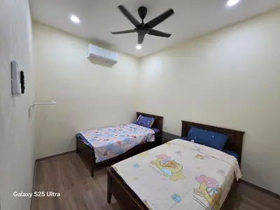 a bedroom with two beds and a ceiling fan at Bliss Homestay in Simpang Ampat