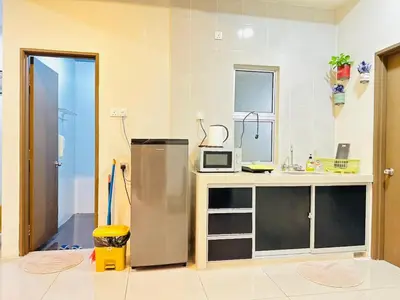 a kitchen with a counter and a refrigerator in it at Homestay Golden Hills Apartment Penthouse in Brinchang