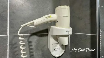 a hair dryer attached to a wall with a phone at Sunway Onsen Suite Theme Park View 2BR in Ipoh