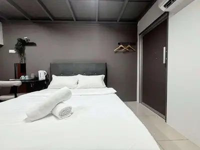 a bedroom with a bed with white sheets and pillows at Gather lnn in George Town