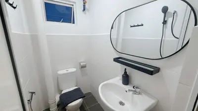 a small bathroom with a sink and a mirror at Gather lnn in George Town