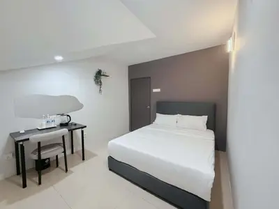 a bedroom with a white bed and a table with a chair at Gather lnn in George Town
