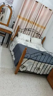 a bedroom with a bed with a wooden frame and a mirror at Sutera Homestay in Sungai Petani
