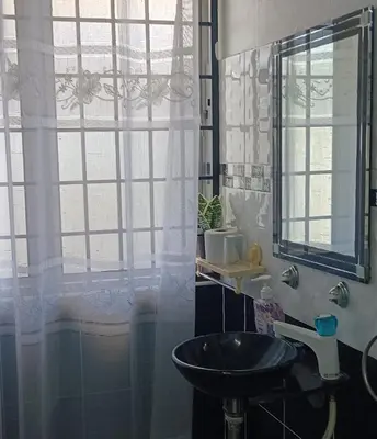 a bathroom with a sink and a shower curtain at Sutera Homestay in Sungai Petani