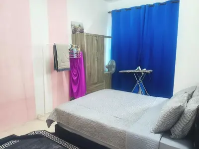 a bedroom with a bed and a blue curtain at Ian's homestay II tanahrata chighlands in Tanah Rata