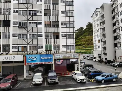 a parking lot with cars parked in front of a building at Ian's homestay II tanahrata chighlands in Tanah Rata