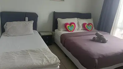 two beds with heart pillows in a bedroom at Skyhauz Ipoh Cityview 2BR Homestay in Ipoh