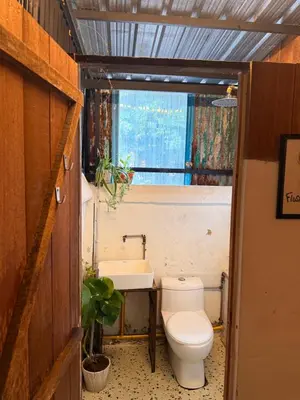 a bathroom with a toilet and a sink at Just House - Rooms & Curios in George Town
