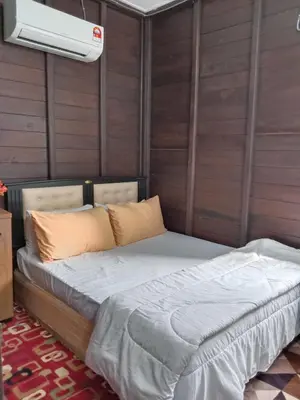 a bed in a room with a ceiling fan at Pak Ayie Homestay in Batu Kurau