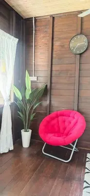 a red chair in a room with a plant at Pak Ayie Homestay in Batu Kurau