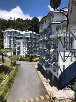 an empty street next to a large apartment building at Cameron Highland 3 Bedroom Apartment in Cameron Highlands